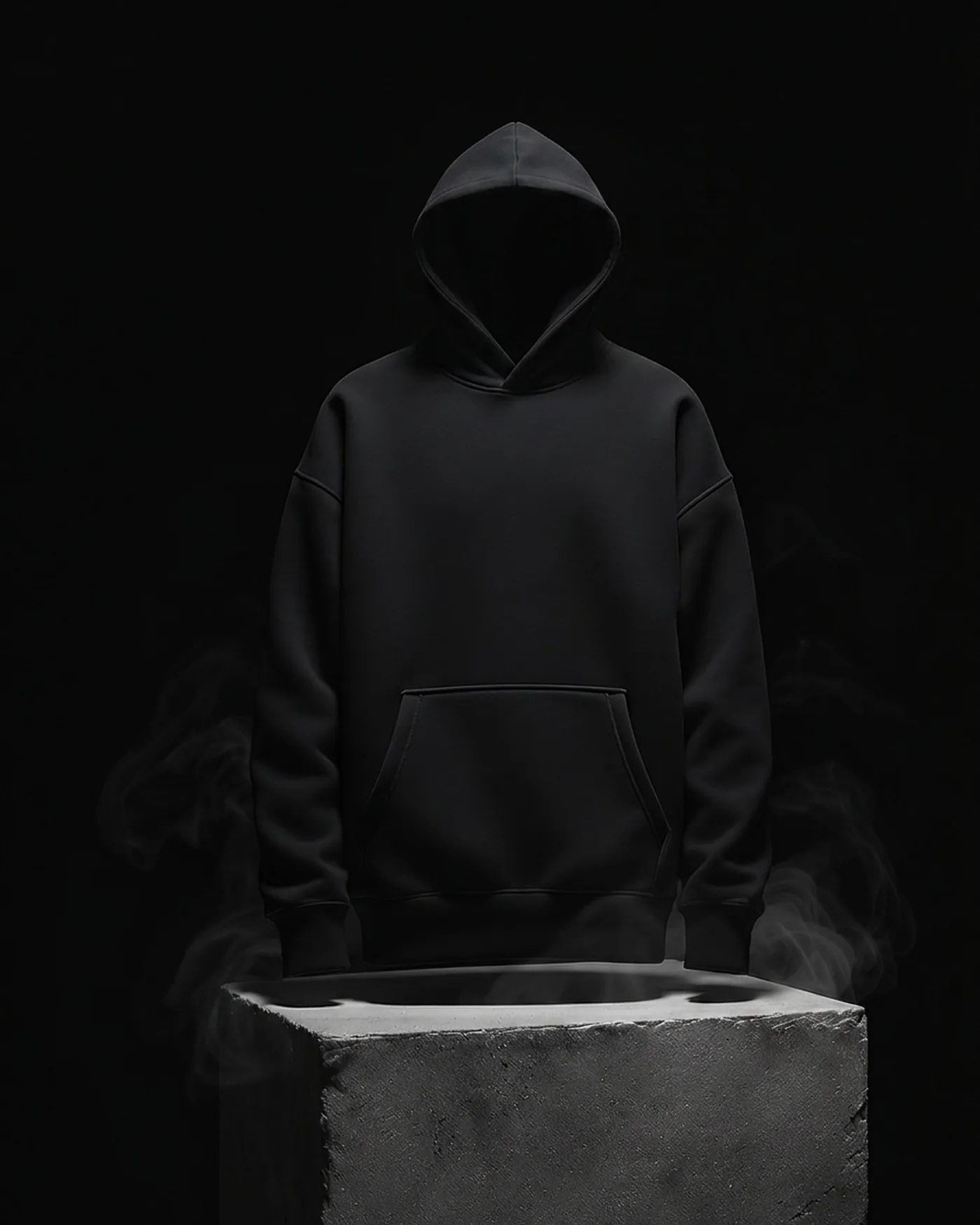 An ink-black heavyweight hoodie on a concrete plinth in a dark void, smoke drifting through the raking light.